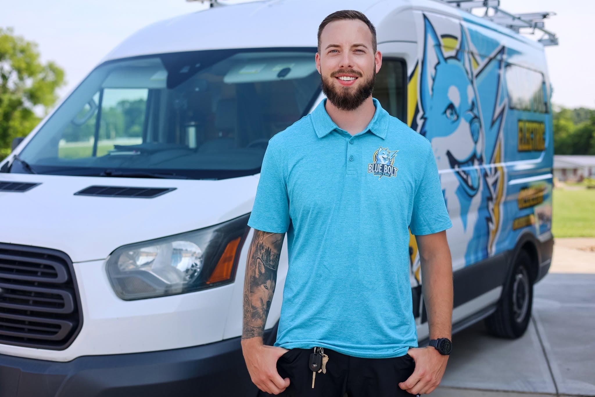 Spencer McGuire, owner of Blue Bolt Electric, standing in front of his service van in Harrison, OH