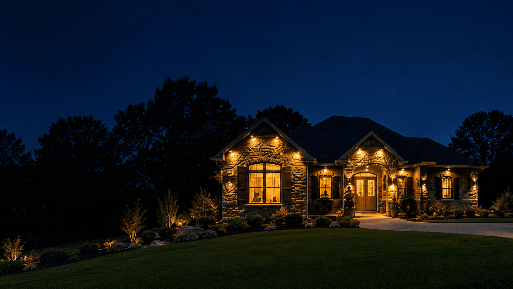 Stone home exterior lit at night, example of outdoor lighting work by Blue Bolt Electric in the Cincinnati Tri-State